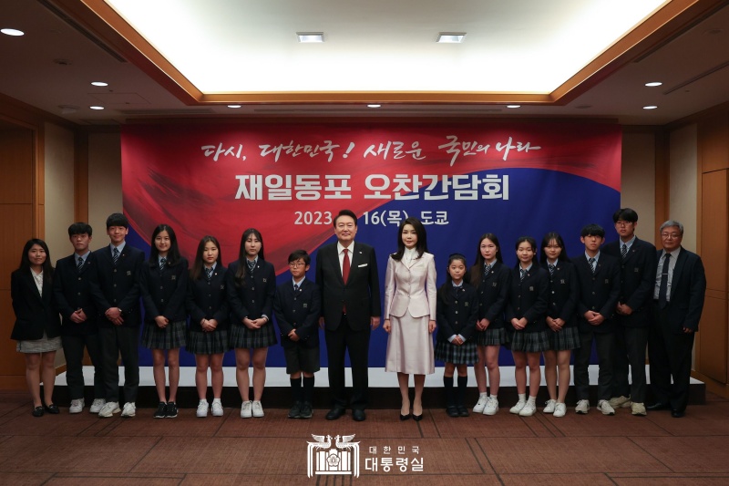 President Yoon Suk Yeol (eighth from left) and first lady Kim Keon Hee (ninth from left) on March 16 pose for a group photo with a student choir from Tokyo Korean School at a luncheon roundtable with ethnic Korean residents of Japan at the Imperial Hotel in Tokyo. In the first event of his visit, he thanked and gave the students words of encouragement, saying, "The community of ethnic Korean residents of Japan has been a strong supporter of our country whenever their homeland was in need, and its members contributed to raising Korea's status in Japan by actively working in their respective fields without losing their pride even under difficult conditions."