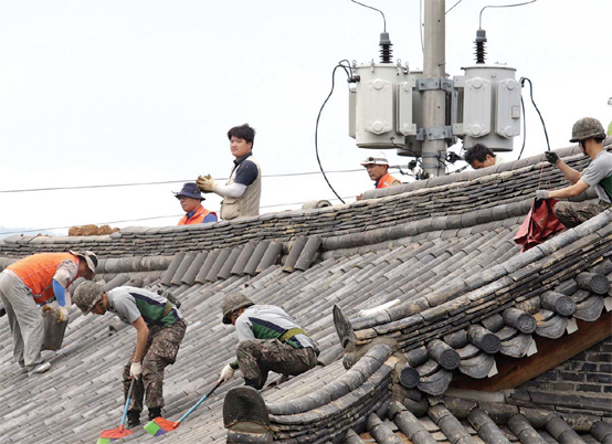 육군50사단 장병들이 경주 지역에 규모 3.5의 여진이 발생한 21일 오후 지진으로 파손된 기와지붕을 보수하고 있다.
