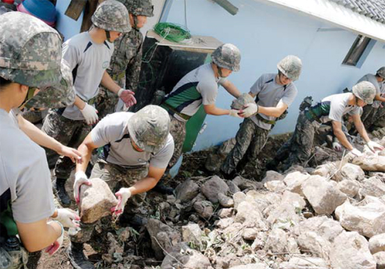 육군50사단 장병들이 무너진 담장 잔해를 정리하고 있다.